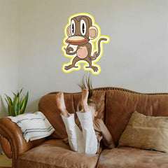 Kid on a brown couch with the 36 inch Pondering Monkey cartoon decal installed on wall above them.